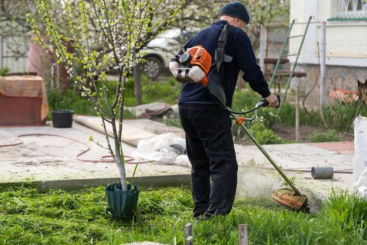 Man mowing the lawn in his garden. Gardener cutting the grass. Lifestyle