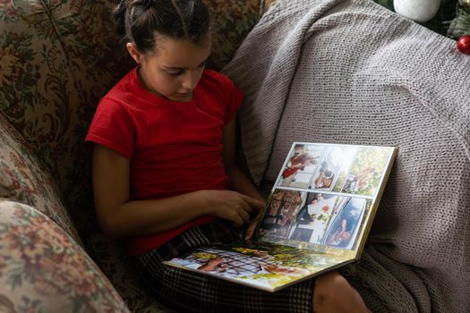 a little girl is holding a photo book.