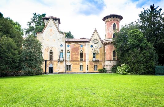 ITALY, MIRADOLO - CIRCA AUGUST 2020: gothic design castle located in an Italian garden, full of mystery, with sunset light.