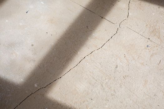 Cracks in the concrete cement screed on the floor after repair. The concrete surface texture is covered with web cracks. Gray stone background