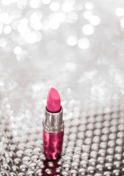 Cosmetic branding, sale and glamour concept - Pink lipstick on silver Christmas, New Years and Valentines Day holiday glitter background, make-up and cosmetics product for luxury beauty brand