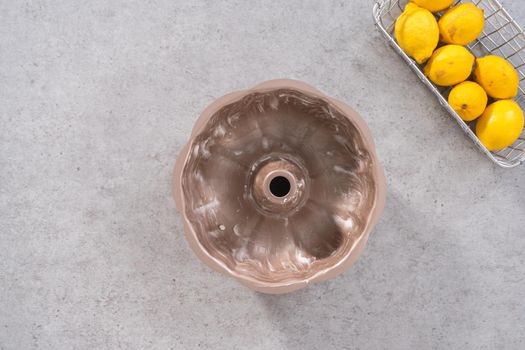 Flat lay. Greasing bundt cake pan to bake lemon cranberry bundt cake.