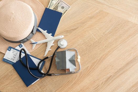 Medical Tourism, medical travel concept. Stethoscope, toy plane and passport on wooden background.