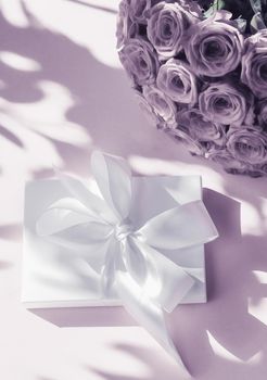 Happy holidays, luxe shopping and love gifts concept - Luxury holiday silk gift box and bouquet of roses on purple background, romantic surprise and flowers as birthday or Valentines Day present