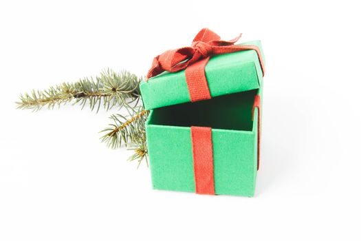 Present. Gift box with a bow. New Year's surprise. Red and green box with a gift. On a white background, top view. Close-up. Tied with a beautiful ribbon for gifting. Under the tree.