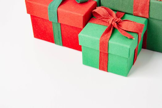 Present. Gift box with a bow. New Year's surprise. Red and green box with a gift. On a white background, top view. Close-up. Tied with a beautiful ribbon for gifting. Under the tree.