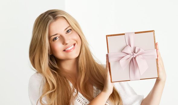 Holiday present for birthday, baby shower, wedding or luxury beauty box subscription delivery, happy woman holding a wrapped pink gift on white background