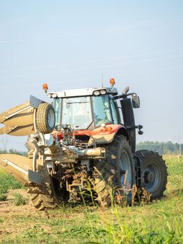 farmer with tractor plowing the land in the countryside.