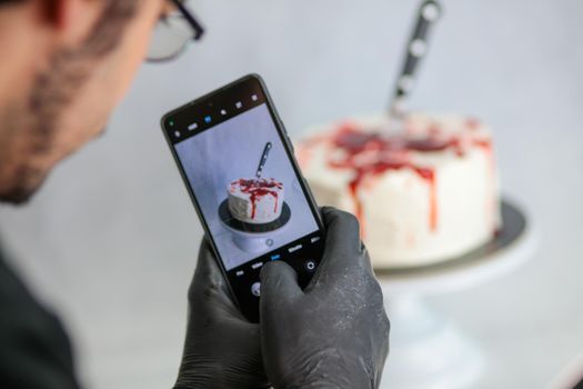 Photographing a bleeding monster cake with knife on cake stand