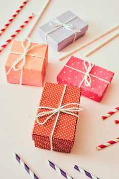 Different holiday colorful gift boxes wrapped in colorful paper and bows on beige background.