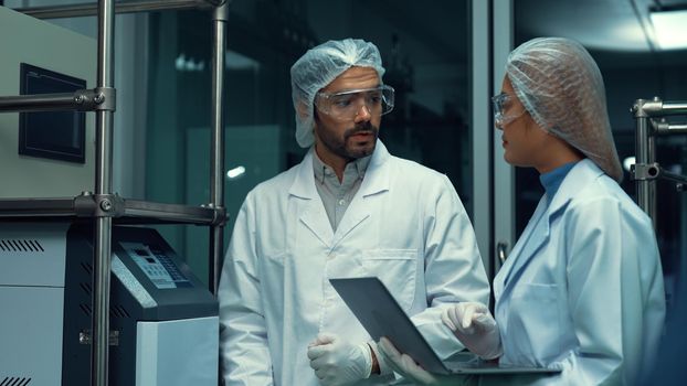 Two scientist in professional uniform working in laboratory for chemical and biomedical experiment
