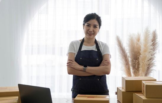 Portrait of Asian young woman SME working with a box at home the workplace.start-up small business owner, small business entrepreneur SME or freelance business online and delivery concept..