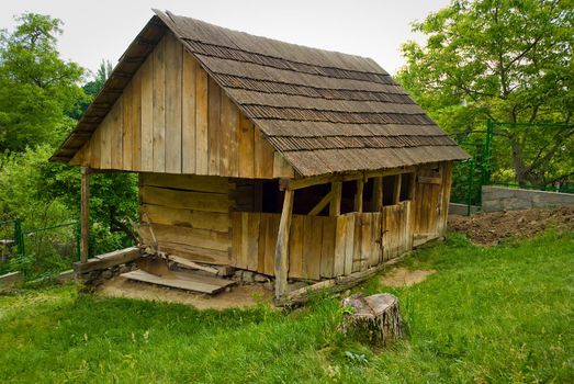 A typical Ukrainian landscape in spring or summer: white clay hut with a straw roof and a tree in the foreground.