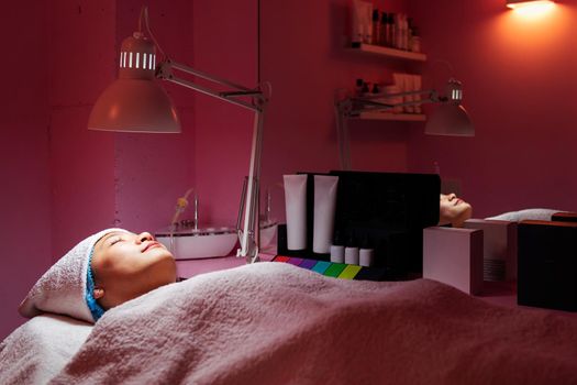 beautiful young woman relaxes lying on the beauty salon couch, concept of body care and wellness