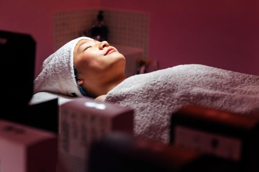 young asian woman relaxes lying on the beauty salon couch, concept of beauty and wellness