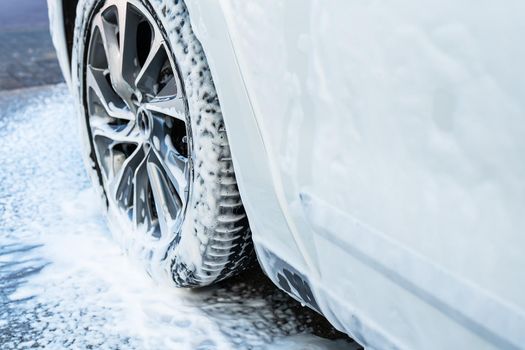 Car wash, white car, wash the car with foam. Self-service sink