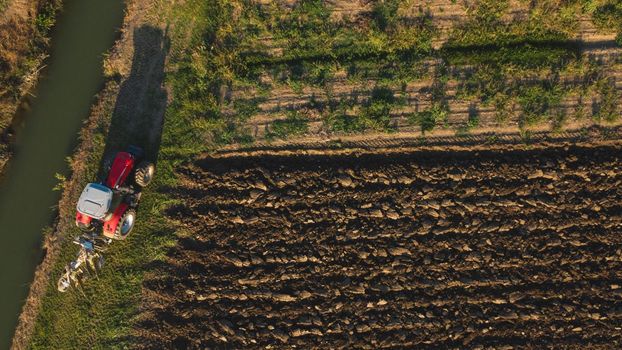 Aerial view with drone of tractor plowing the land in the countryside.