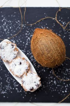 Sweet coconut muffins with chocolate on a white plate. Black background