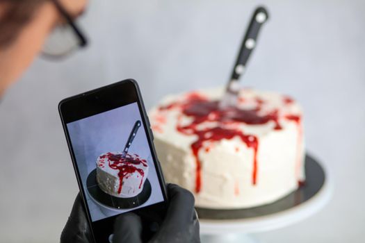 Photographing a bleeding monster cake with knife on cake stand