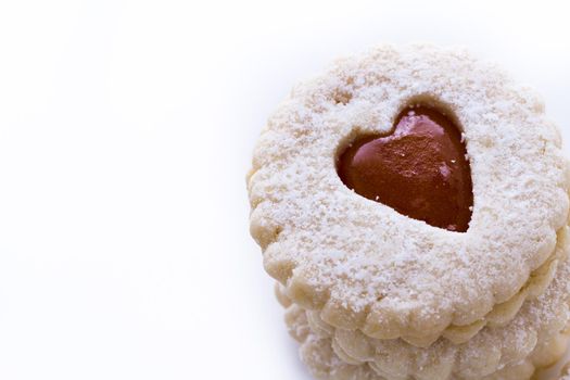 Linzer Torte cookies on white background with powdered sugar sprinkled on top.