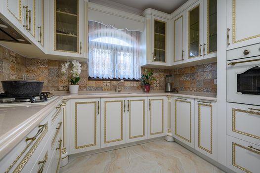 White classic cozy kitchen and dining room in city house interior