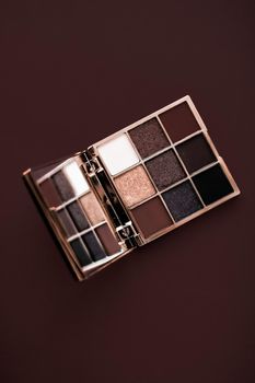 Cosmetic branding, mua and girly concept - Eyeshadow palette and make-up brush on chocolate background, eye shadows cosmetics product for luxury beauty brand promotion and holiday fashion blog design