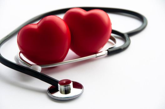 Stethoscope with two heart shapes on white background. Copy space and health concept.