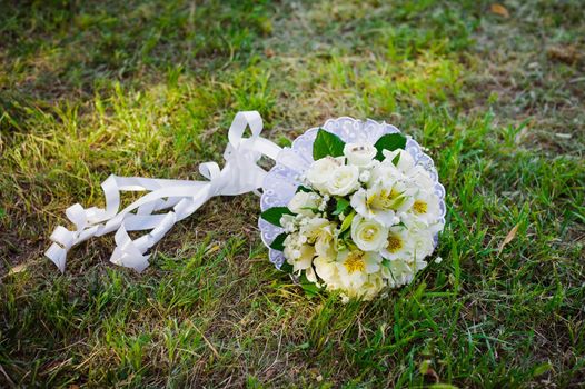 Bridal wedding bouquet of flowers. Wedding bouquet of yellow and white roses lying on a grass