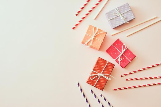 Different holiday colorful gift boxes wrapped in colorful paper and bows on beige background.