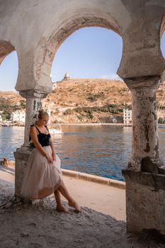 Side view portrait of a relaxed woman breathing fresh air at the seaside. She stands near the old column