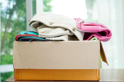 Clothes donations in cardboard box for volunteer.