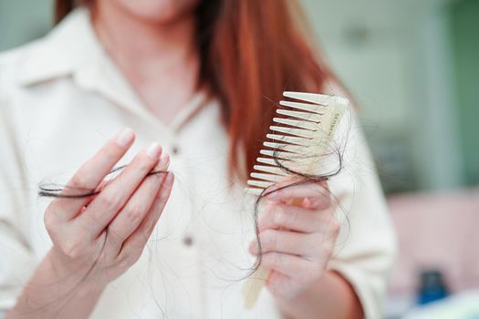 Asian woman have problem with long hair loss attach to comb brush.