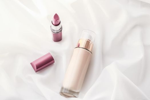 Cosmetic branding, glamour and skincare concept - Beige tonal cream bottle make-up fluid foundation base and pink lipstick on silk background, cosmetics products as luxury beauty brand holiday design