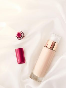 Cosmetic branding, glamour and skincare concept - Beige tonal cream bottle make-up fluid foundation base and red lipstick on silk background, cosmetics products as luxury beauty brand holiday design