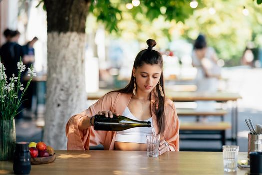 Woman with a cold drink sitting in a cafe on the street