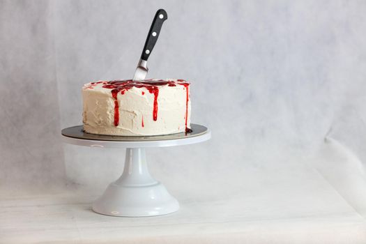 Bleeding monster cake with knife on cake stand