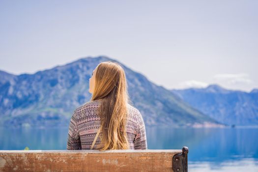 A woman sits on a bench and admires the view of the Bay of Kotor. Montenegro.