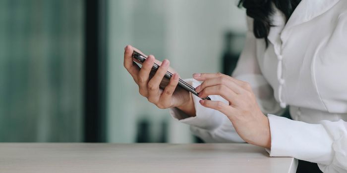 Close up woman hand holding mobile phone, She using in mobile applications and multimedia programs. copy space.