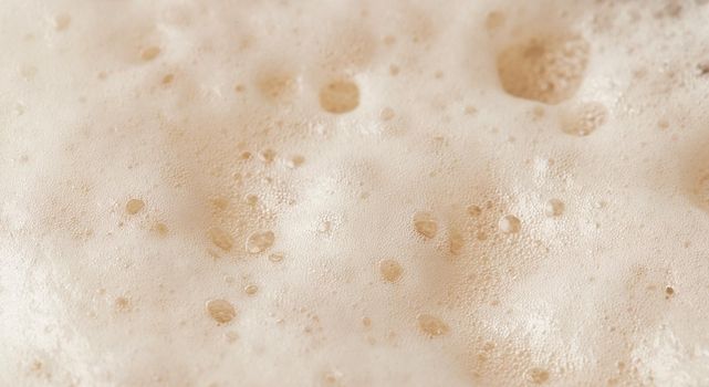 Beer foam top view. Soft fresh Foam on light beer. Bubble froth of beer. Beer foam texture background.
