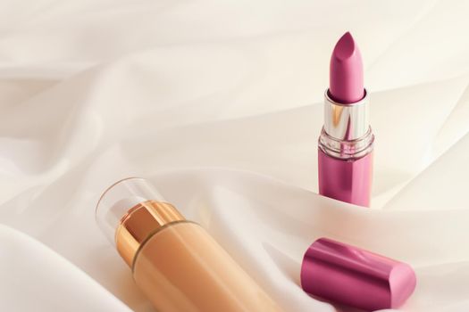 Cosmetic branding, glamour and skincare concept - Beige tonal cream bottle make-up fluid foundation base and pink lipstick on silk background, cosmetics products as luxury beauty brand holiday design