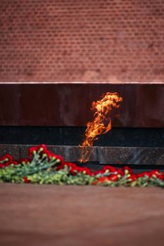 Flowers by the Eternal Flame. Eternal Flame in the Kremlin. Guard of Honor at the tomb of the Unknown Soldier at the wall of Moscow Kremlin. 11.05.2022 Moscow, Russia.