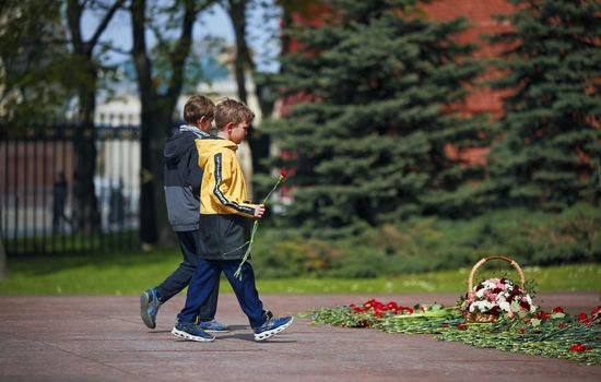 Laying flowers to the Eternal Flame. Eternal Flame in the Kremlin. Guard of Honor at the tomb of the Unknown Soldier at the wall of Moscow Kremlin. 11.05.2022 Moscow, Russia.