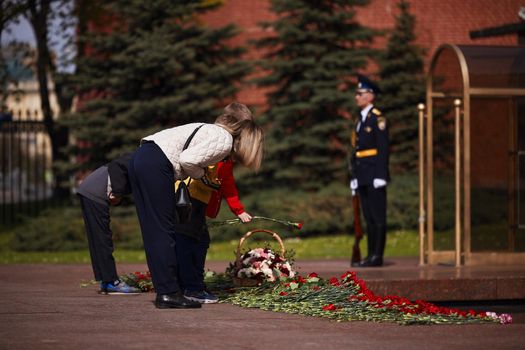 Laying flowers to the Eternal Flame. Eternal Flame in the Kremlin. Guard of Honor at the tomb of the Unknown Soldier at the wall of Moscow Kremlin. 11.05.2022 Moscow, Russia.