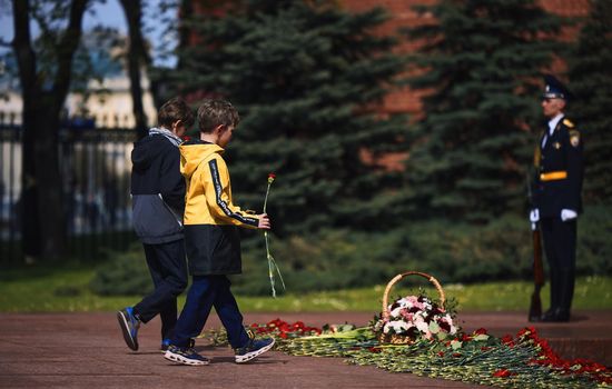 Laying flowers to the Eternal Flame. Eternal Flame in the Kremlin. Guard of Honor at the tomb of the Unknown Soldier at the wall of Moscow Kremlin. 11.05.2022 Moscow, Russia.