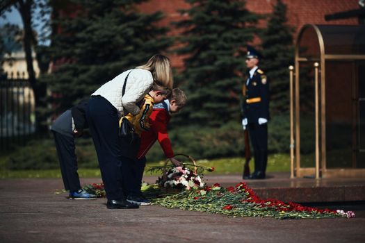 Laying flowers to the Eternal Flame. Eternal Flame in the Kremlin. Guard of Honor at the tomb of the Unknown Soldier at the wall of Moscow Kremlin. 11.05.2022 Moscow, Russia.