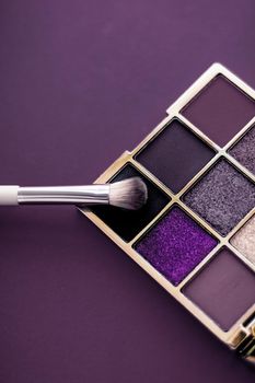 Cosmetic branding, mua and girly concept - Eyeshadow palette and make-up brush on purple background, eye shadows cosmetics product as luxury beauty brand promotion and holiday fashion blog design