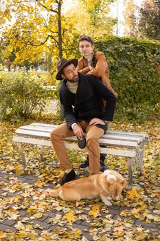 Father and son with a pet on a walk in the autumn park.