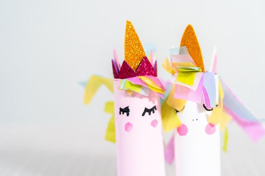 Making a unicorn out of the toilet paper roll and craft paper.