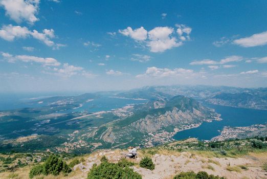 Bride and groom sit on a bench on the top of the mountain and look at the valley. High quality photo