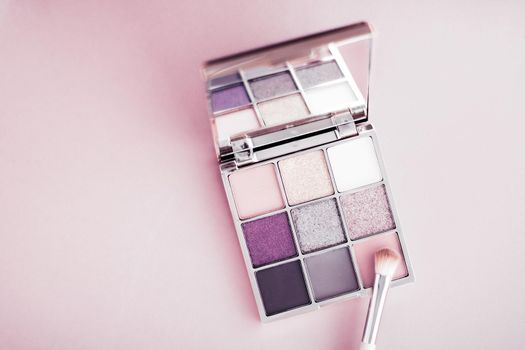 Cosmetic branding, mua and girly concept - Eyeshadow palette and make-up brush on blush pink background, eye shadows cosmetics product as luxury beauty brand promotion and holiday fashion blog design